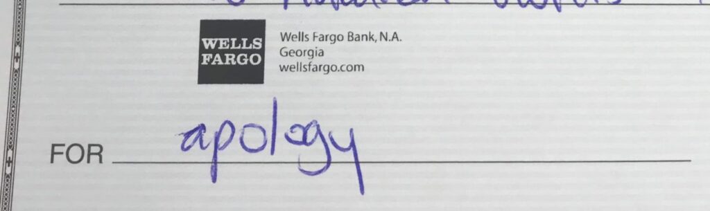 A check with "Wells Fargo Bank, N.A." and "wellsfargo.com" printed on it. The memo line has "apology" handwritten in blue ink.