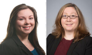Two women are posed in a side-by-side portrait. The woman on the left has long brown hair, wearing a dark blazer. The woman on the right has shoulder-length light brown hair, glasses, and a pearl necklace, also in a dark blazer. Both are smiling.
