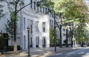 A street view of the State Bar of Georgia building, featuring a white facade with tall windows and 