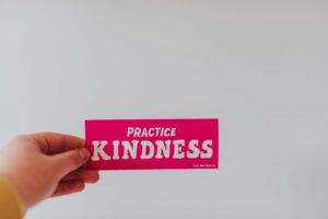 A hand holds a bright pink card with the message 