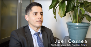 A man in a suit and tie sits in an office setting with green plants in the background. The text reads 