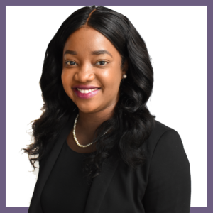 A person with long, dark hair and a friendly smile wearing a black suit and a pearl necklace. The background is white, framed by a purple border.