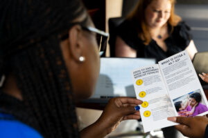 A person holding a brochure titled 