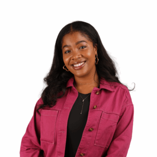 A woman with long black hair wearing a magenta jacket over a black top smiles at the camera against a plain white background.