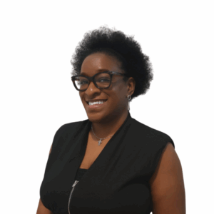 A woman with short curly hair, wearing glasses, a sleeveless black top, and a necklace, smiling against a plain white background.