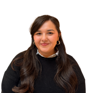 A woman with long dark hair, wearing a black sweater and hoop earrings, smiles at the camera against a plain white background.