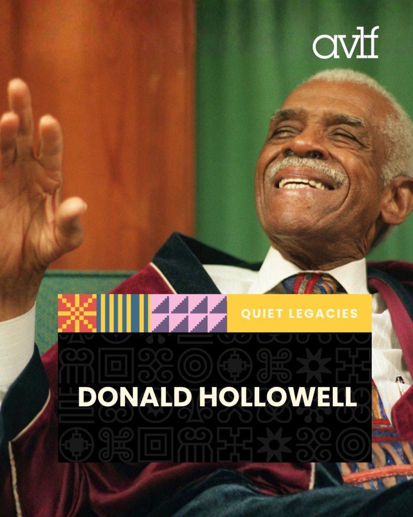 An elderly man with gray hair and a mustache smiles and gestures with his hand while seated. The text reads: "Quiet Legacies: Donald Hollowell." The background is warm, with a patterned banner and decorative symbols.